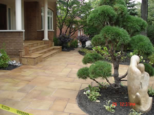After: interlocking cut stone patio and steps with japanese-style planting and statue