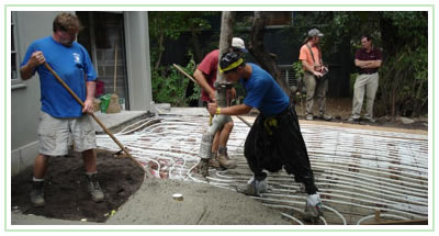 Pouring concrete over heating coils in a client's driveway.