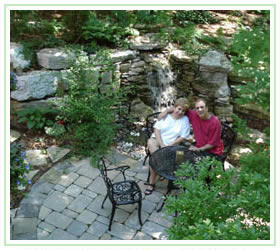 Satisfied customers sitting at wrought iron table on flagstone patio 