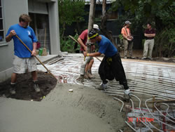 Spreading the concrete over the heating coils at the front entrance and driveway